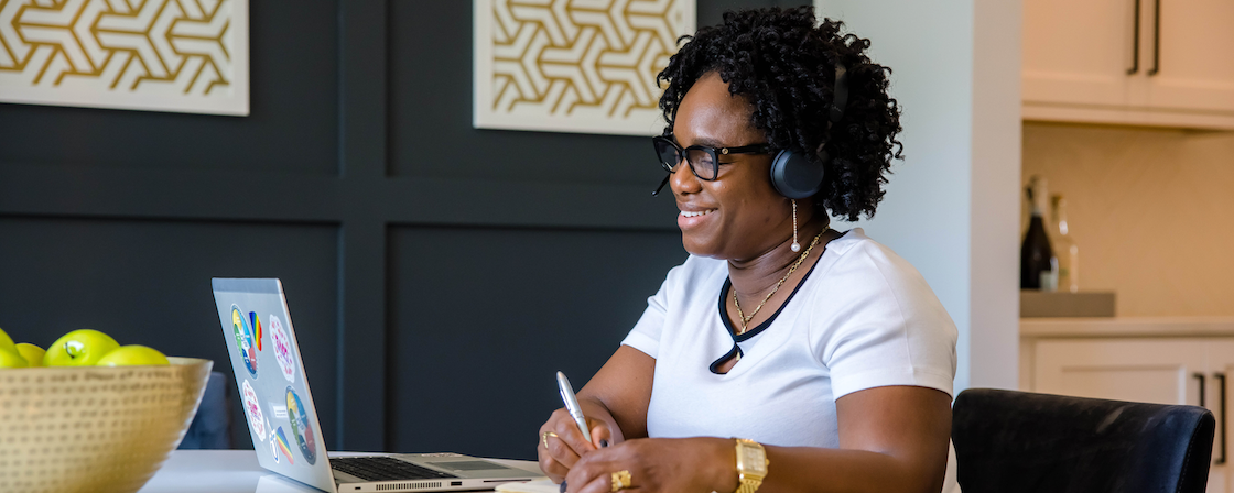Jackie Cooper, Capital One associate, sits at her kitchen table with her laptop and headset and works from home